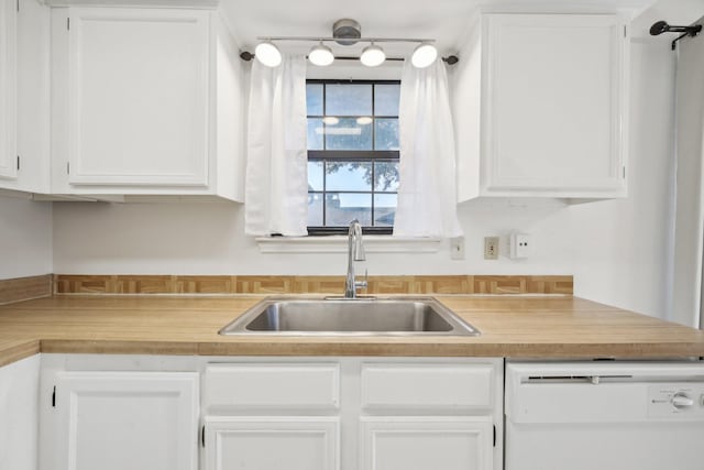 kitchen featuring white dishwasher, white cabinetry, and sink