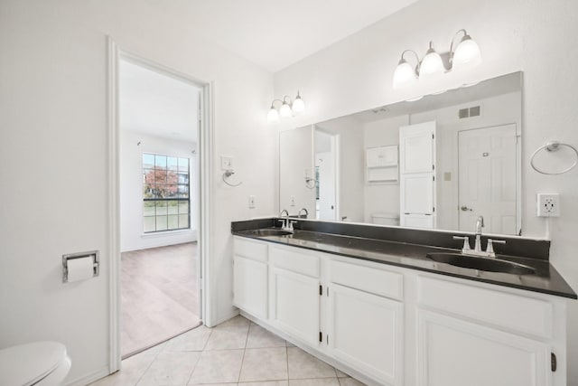 bathroom with tile patterned flooring, vanity, and toilet