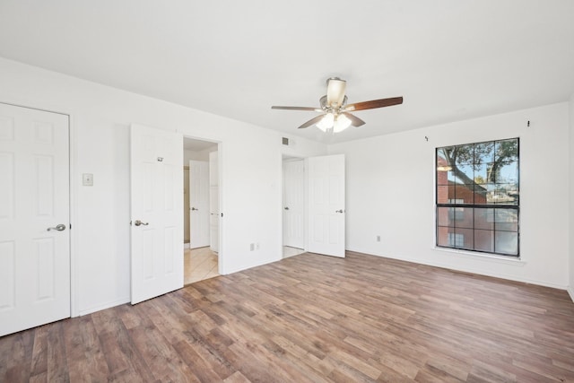 unfurnished bedroom with ceiling fan and light wood-type flooring