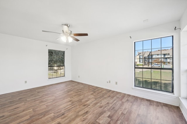 spare room featuring hardwood / wood-style flooring, plenty of natural light, and ceiling fan