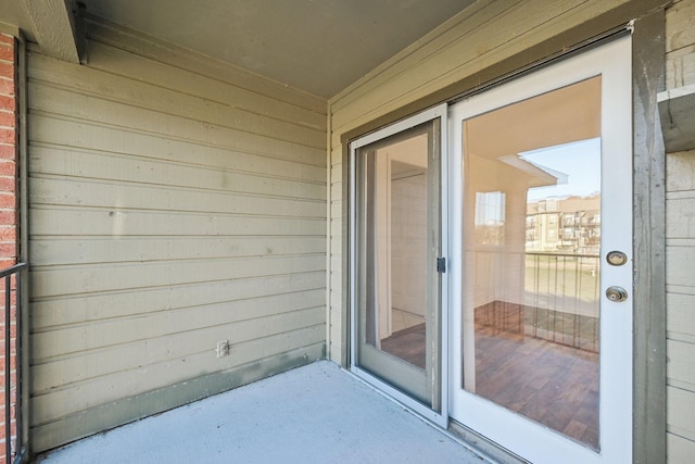 view of exterior entry with a balcony