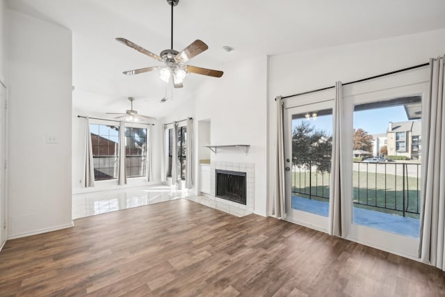 unfurnished living room with a fireplace, dark hardwood / wood-style floors, vaulted ceiling, and ceiling fan