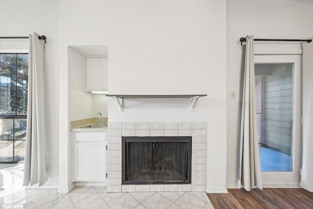 room details featuring a tile fireplace, wood-type flooring, and sink