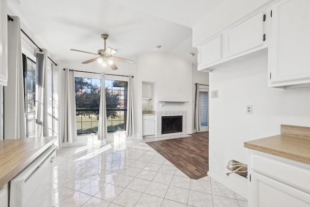 unfurnished living room with ceiling fan, light tile patterned flooring, and vaulted ceiling