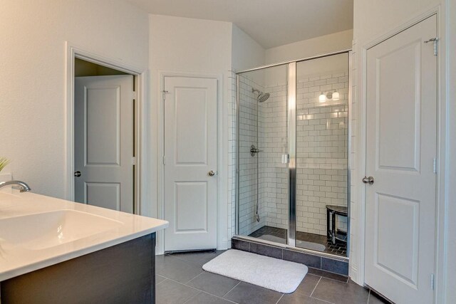 bathroom with tile patterned floors, vanity, and an enclosed shower