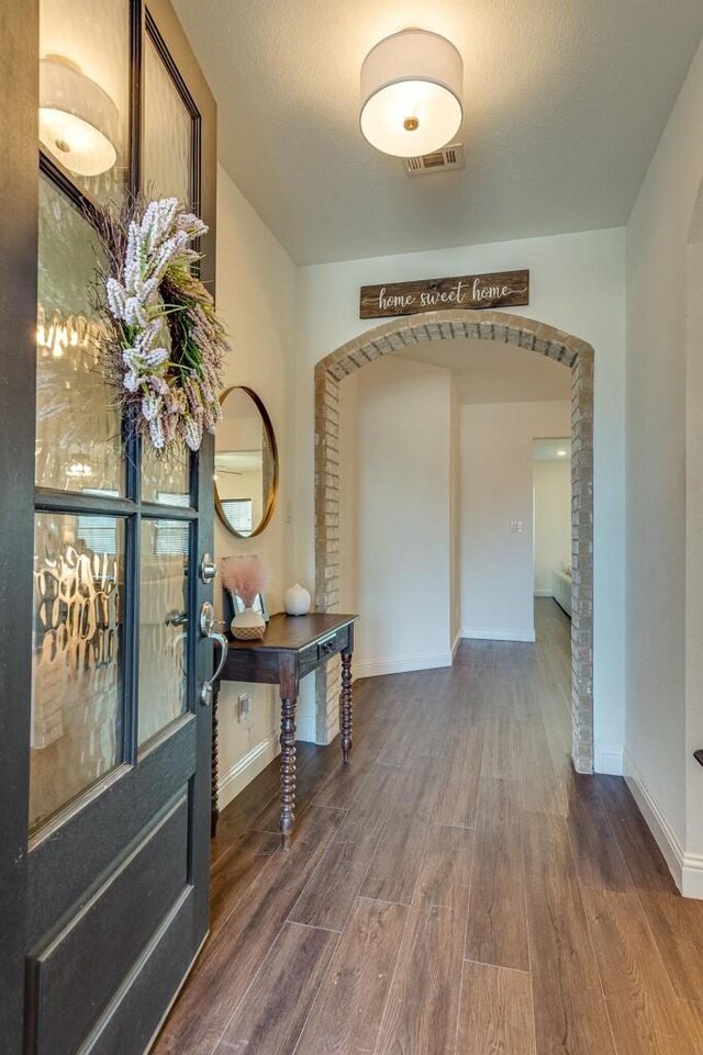 entryway with dark wood-type flooring and a textured ceiling