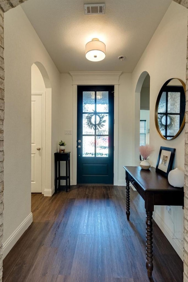 entryway featuring a textured ceiling and dark hardwood / wood-style flooring