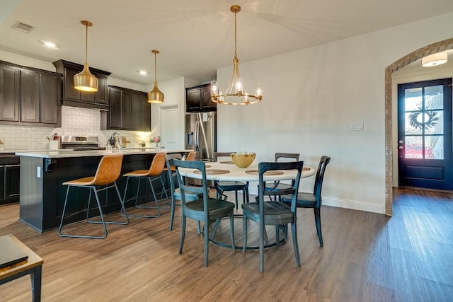 dining area featuring light wood-type flooring and a notable chandelier