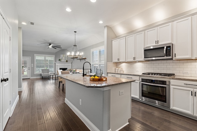 kitchen featuring a center island with sink, white cabinetry, and appliances with stainless steel finishes