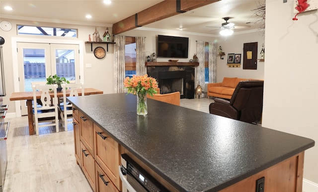 kitchen featuring ornamental molding, light hardwood / wood-style floors, ceiling fan, and a kitchen island