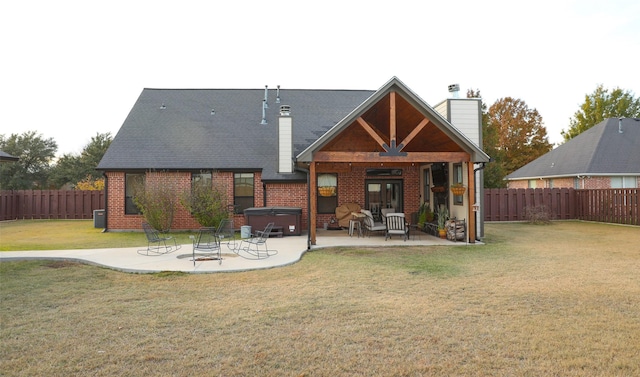 back of property featuring a yard, a patio area, a hot tub, and ceiling fan