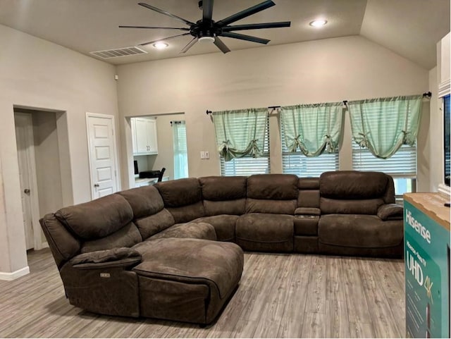 living room with ceiling fan, lofted ceiling, and light hardwood / wood-style floors