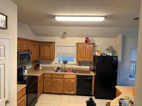 kitchen with light tile patterned floors, sink, vaulted ceiling, and black appliances