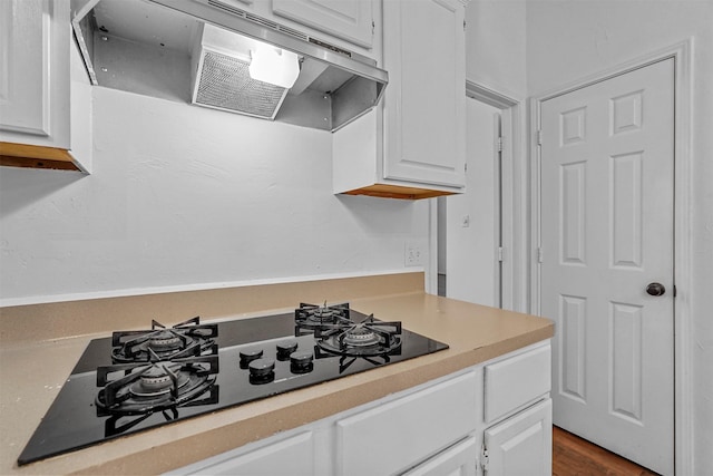 kitchen with white cabinetry, dark hardwood / wood-style floors, range hood, and black gas cooktop