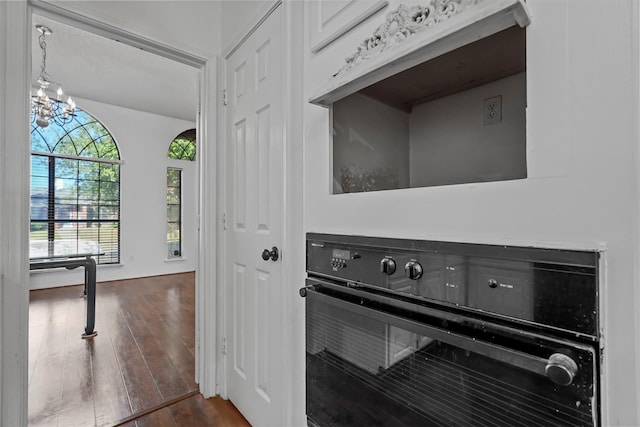 interior space with an inviting chandelier, dark hardwood / wood-style floors, and oven