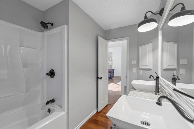 bathroom with shower / bathtub combination, wood-type flooring, a textured ceiling, and vanity