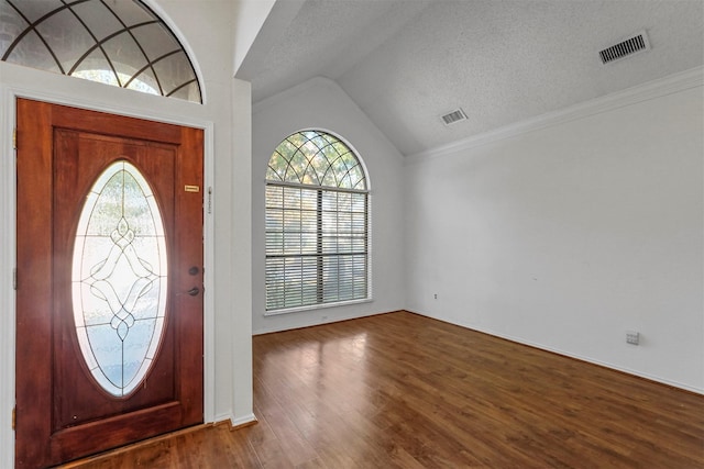 entryway featuring vaulted ceiling, hardwood / wood-style floors, a textured ceiling, and a wealth of natural light