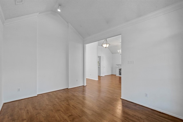 unfurnished living room with wood-type flooring, ornamental molding, a textured ceiling, and vaulted ceiling