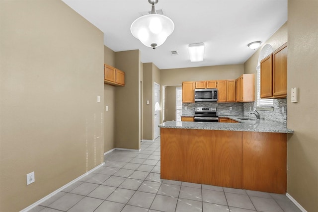 kitchen with sink, backsplash, kitchen peninsula, light tile patterned floors, and appliances with stainless steel finishes