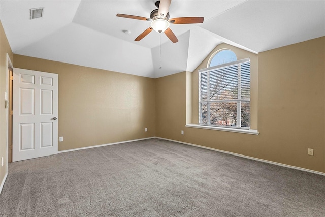 carpeted spare room featuring vaulted ceiling and ceiling fan