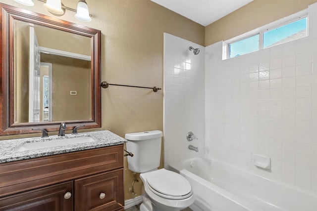 full bathroom featuring vanity, tiled shower / bath combo, and toilet