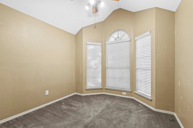 carpeted spare room featuring ceiling fan and vaulted ceiling