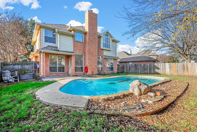 rear view of house featuring a fenced in pool