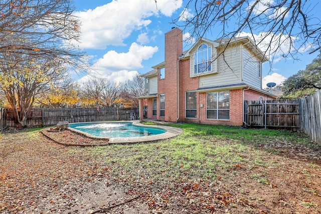 back of house featuring a fenced in pool and a yard