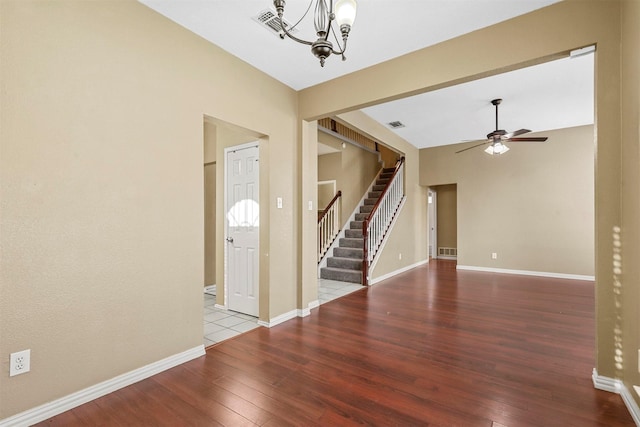 entryway with ceiling fan with notable chandelier and wood-type flooring