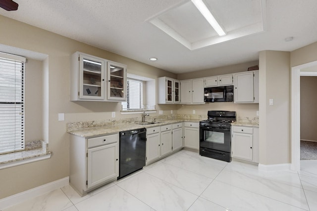 kitchen featuring black appliances, a healthy amount of sunlight, and white cabinets