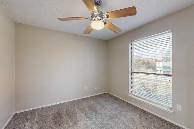 unfurnished room with ceiling fan, carpet flooring, and a textured ceiling