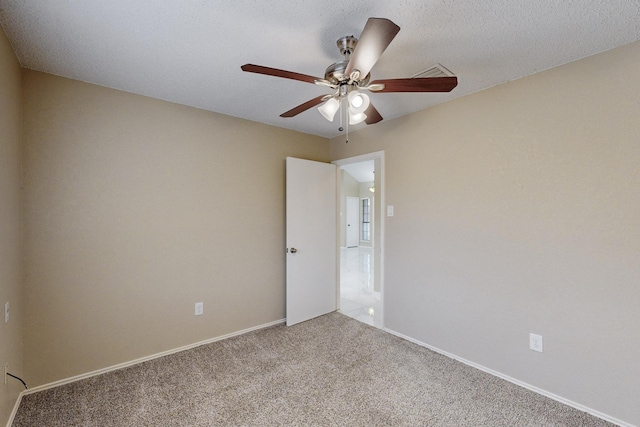 carpeted empty room with ceiling fan and a textured ceiling