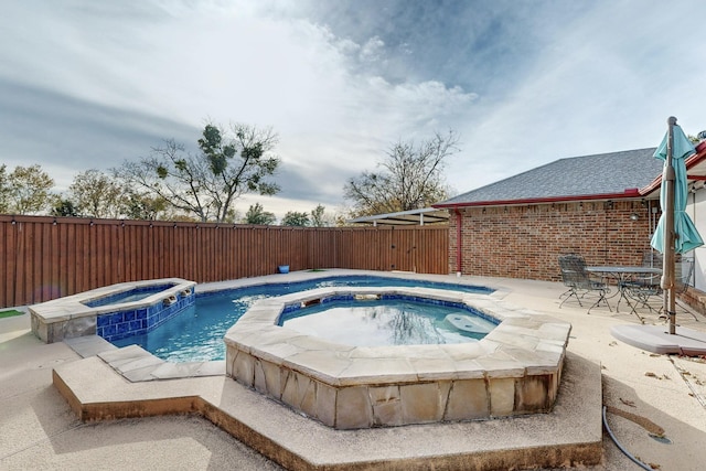 view of swimming pool featuring a patio area and an in ground hot tub