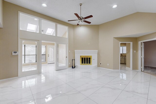 unfurnished living room with french doors, a textured ceiling, high vaulted ceiling, and ceiling fan