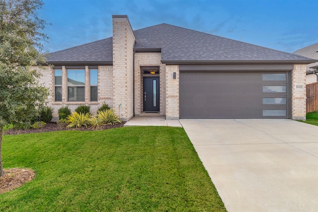 view of front of home with a front lawn and a garage