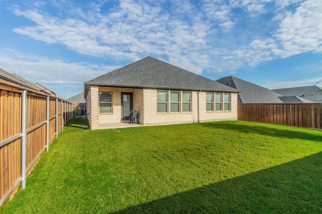 back of property with a lawn, central air condition unit, and a patio