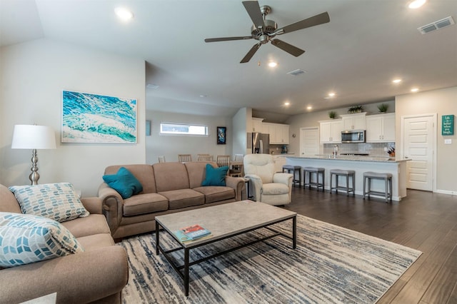 living room featuring ceiling fan, dark hardwood / wood-style flooring, and lofted ceiling