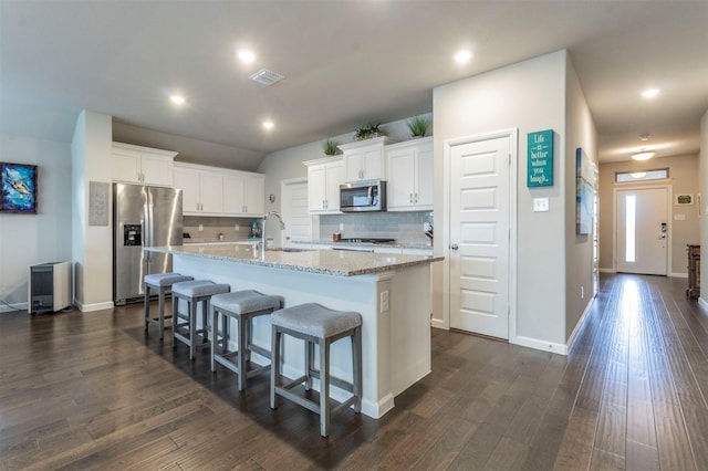 kitchen featuring stainless steel appliances, sink, dark hardwood / wood-style floors, white cabinetry, and an island with sink