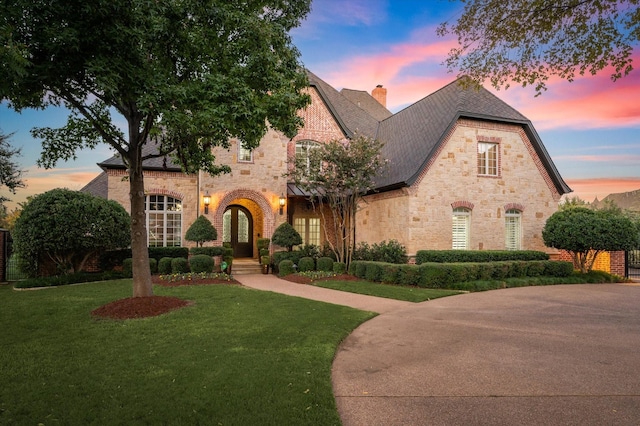 french provincial home featuring a yard