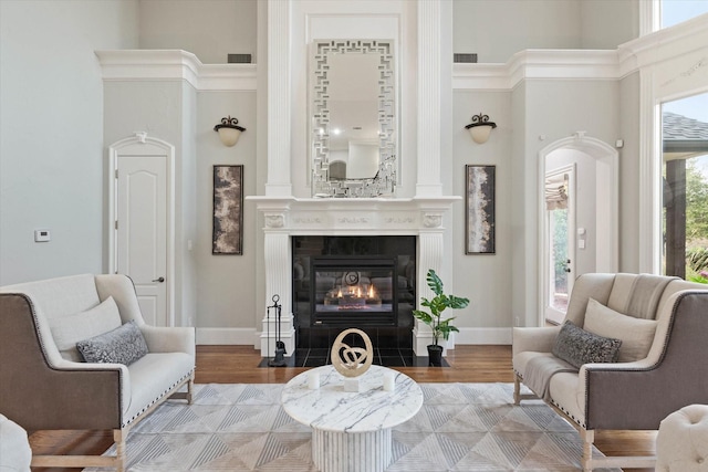 sitting room with a high ceiling, light hardwood / wood-style flooring, and a wealth of natural light