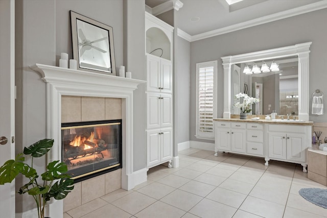 bathroom featuring a fireplace, vanity, ornamental molding, and tile patterned flooring