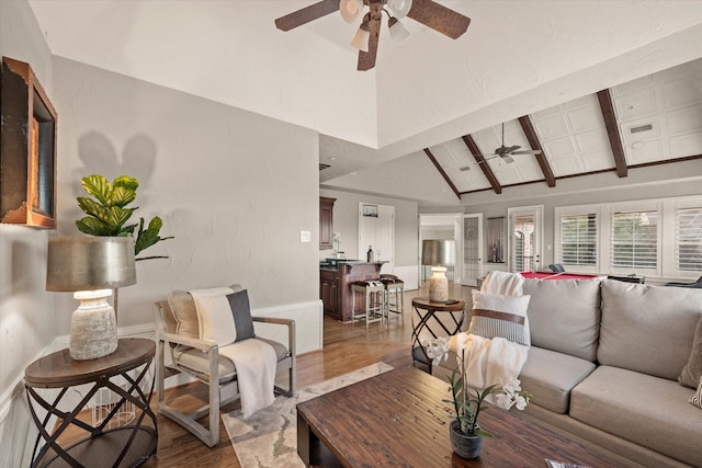 living room featuring hardwood / wood-style floors, high vaulted ceiling, and beam ceiling