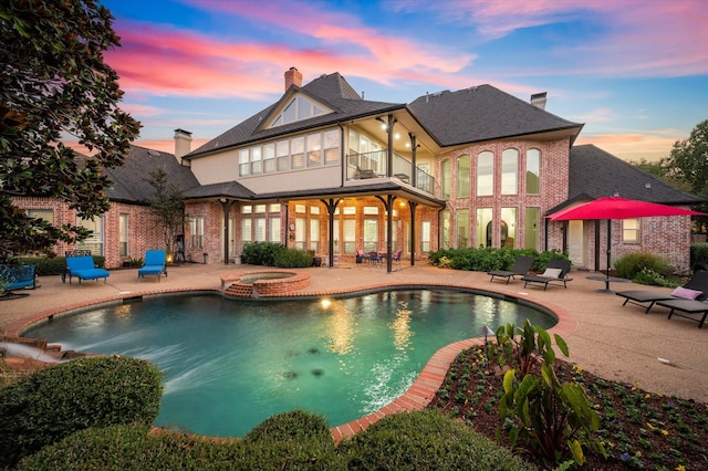 exterior space featuring an in ground hot tub and a patio