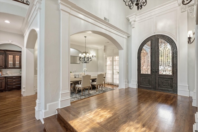 entryway with french doors, a towering ceiling, dark hardwood / wood-style floors, and crown molding