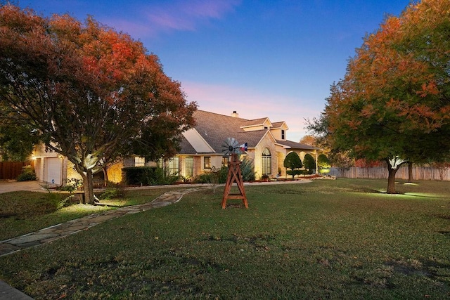 view of front of house with a garage and a lawn