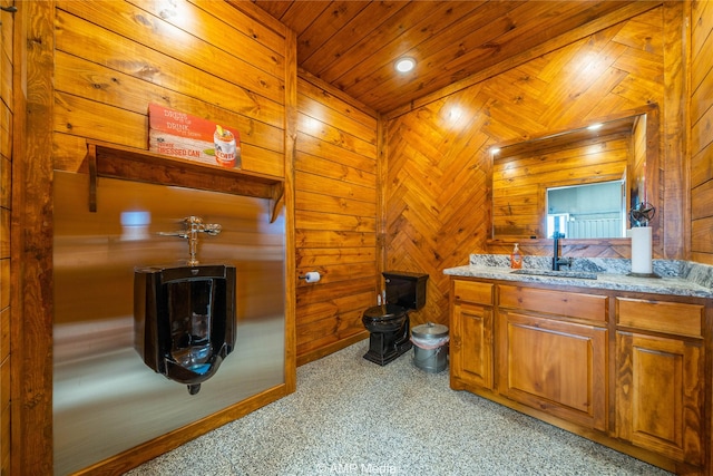 bathroom featuring wood ceiling, vanity, and wood walls