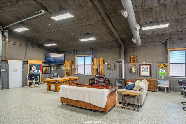 living room with a healthy amount of sunlight, a wood stove, and billiards