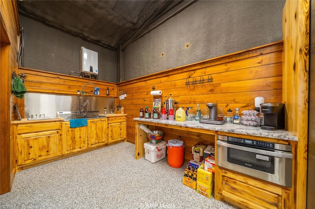 kitchen with wooden walls, light colored carpet, and stainless steel oven