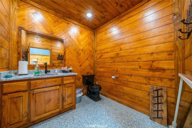 bathroom with vanity, wooden ceiling, and wood walls