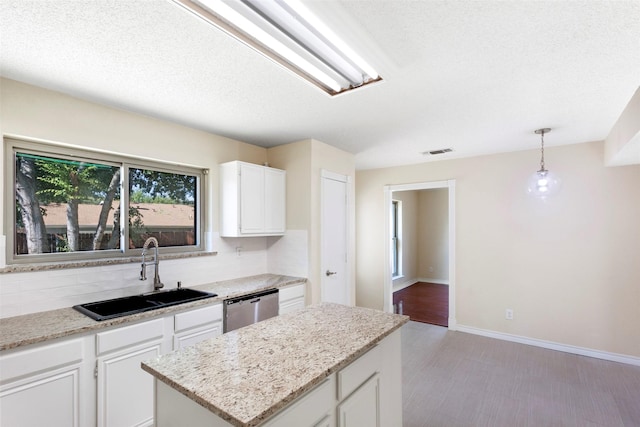 kitchen with a kitchen island, pendant lighting, dishwasher, white cabinetry, and sink